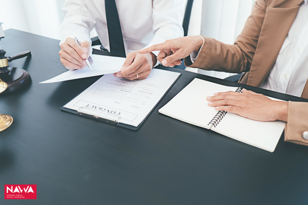 two people at the desk, checking the documents