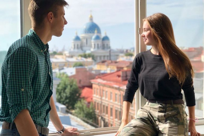 Para studentów siedzi przy oknie, w tle architektura Sankt Petersburga