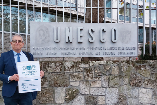 prof. Robert Hirsch na tle napisu UNESCO pod siedzibą UNESCO