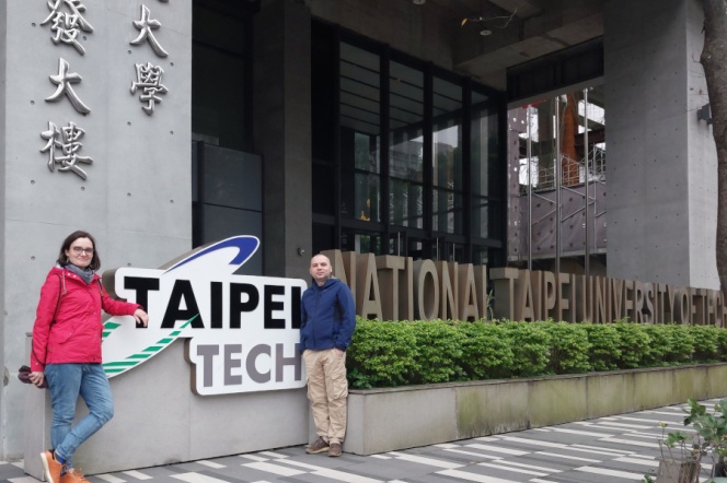 2 osoby pozują do zdjęcia przy logo Taipei Tech