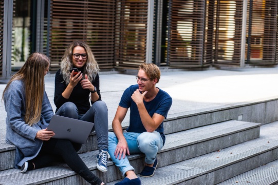 students sitting outside a building