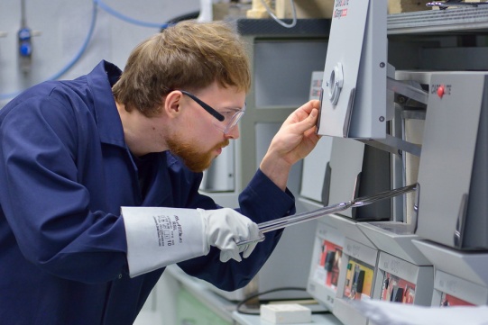 mężczyzna wkłada próbkę do sprzętu laboratoryjnego