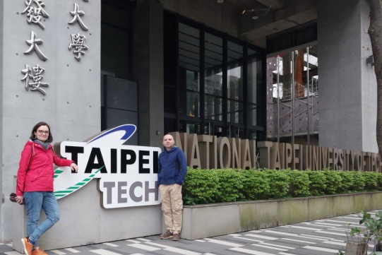 2 osoby pozują do zdjęcia przy logo Taipei Tech