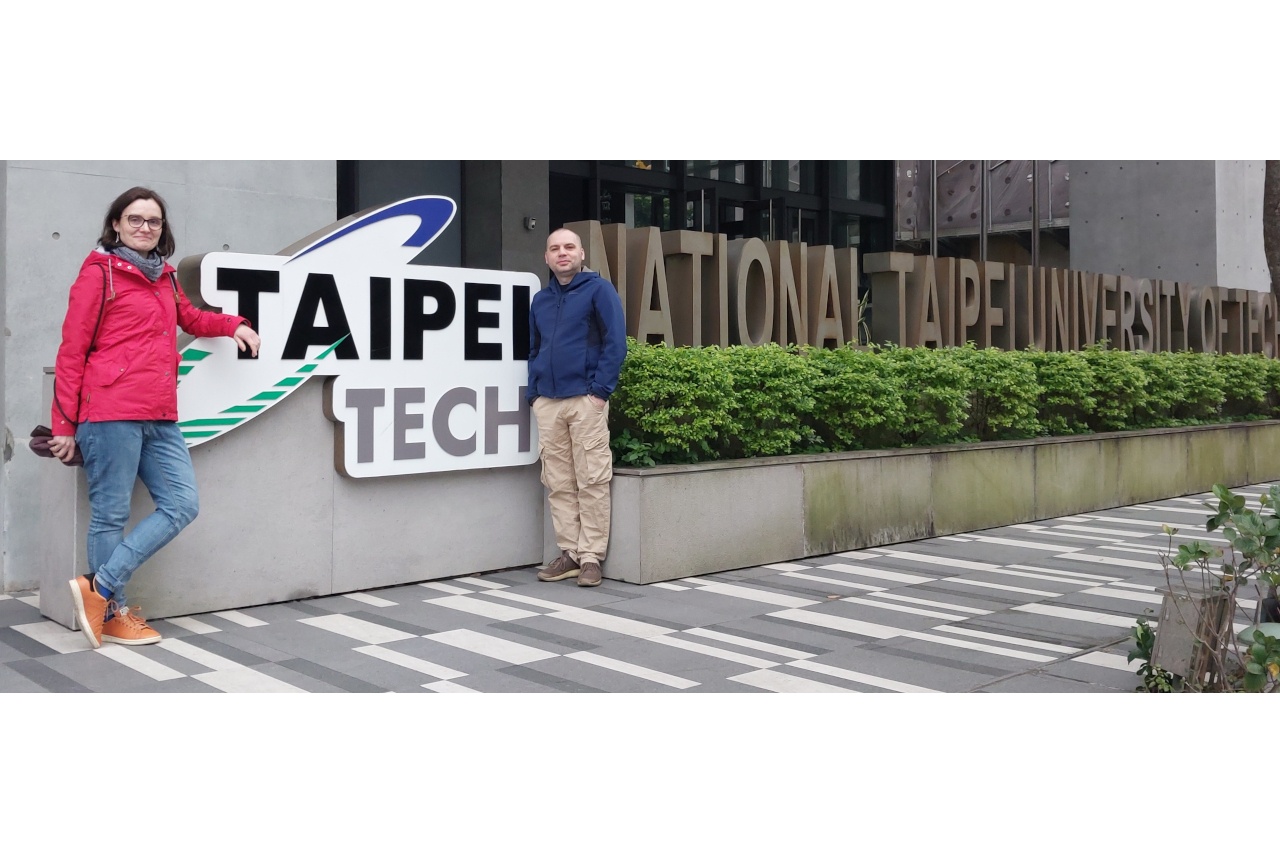 2 osoby pozują do zdjęcia przy logo Taipei Tech