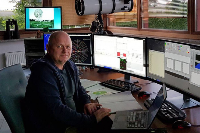 Na zdjęciu prof. Mariusz Figurski siedzi przed monitorami