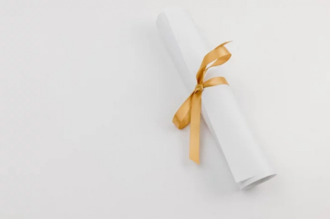 The photo shows a white card with a gold ribbon laid on a white background.