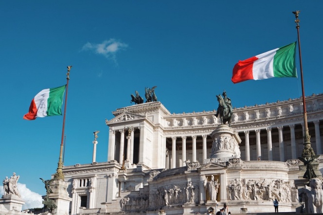 Na zdjęciu widać budynki we Włoszech i flagi Włoch