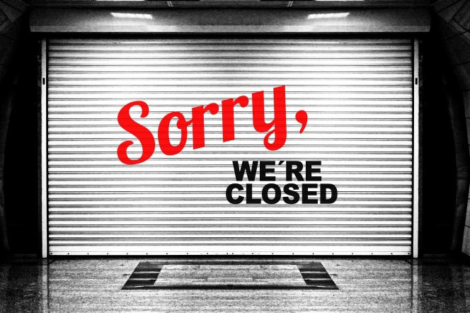 Czarno białe zdjęcie zasuniętej rolety z napisem Sorry, we're closed.