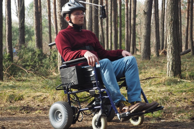 Zdjęcie osoby poruszającej się na wózku po lesie