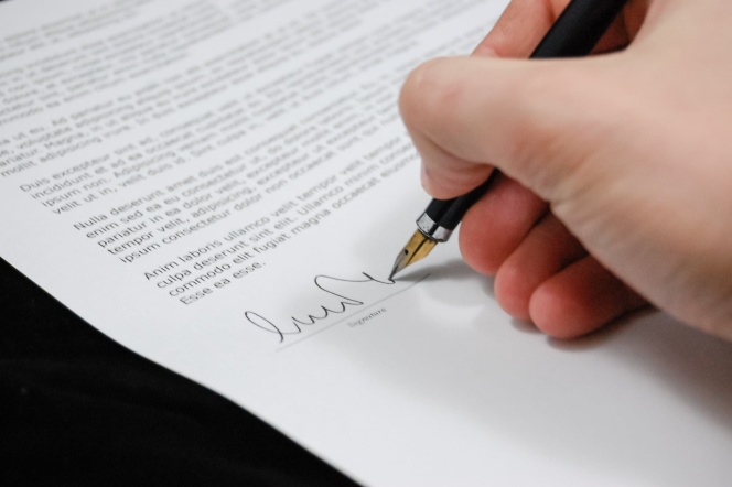 ręka podpisująca dokumenty