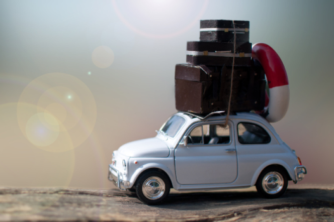 a car carrying suistcases on the roof