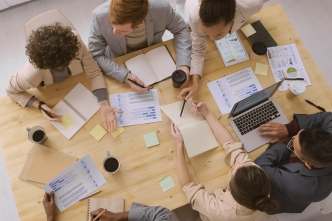 People sitting around the table with laptops.