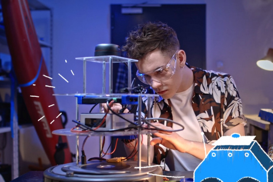 zdjęcie przedstawia studenta pracującego nad urządzeniem