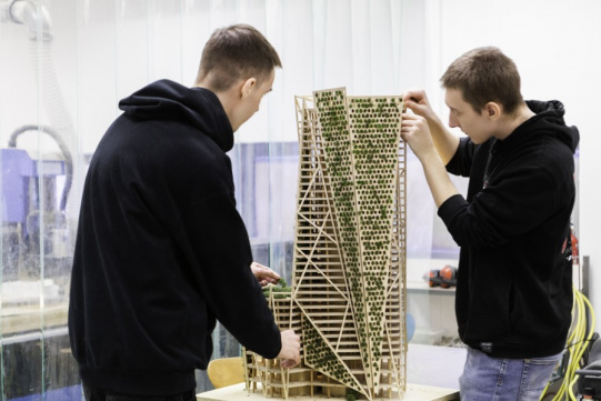 Studenci budują drewnianą konstrukcję 