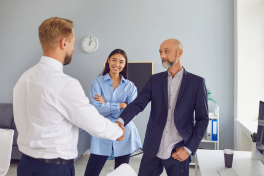The picture shows three people in conversation.