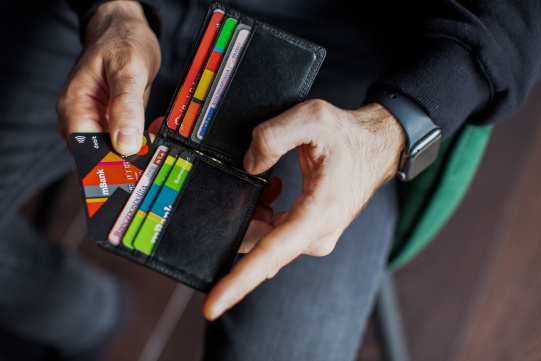 Na zdjęciu widać człowieka trzymającego portfel