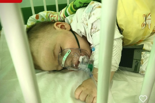 Chłopiec leżący w łóżeczku