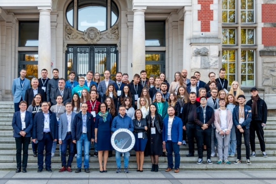 Grupa osób stojąca na schodach przed Gmachem Głównym PG