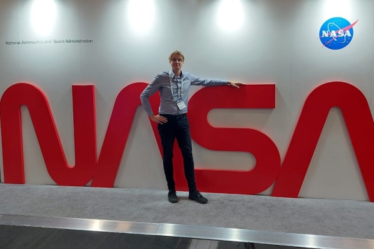 Marcin Jasiukowicz na tle napisu NASA 
