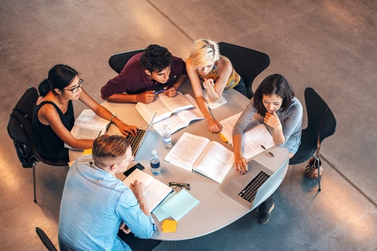 grupa studentów przy wspólnej pracy badawczej 