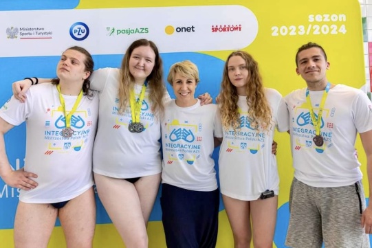 Reprezentacja Politechniki Gdańskiej pozująca do zdjęcia. Trzy osoby mają zawieszone na szyi medale. 