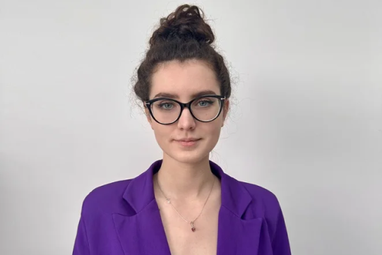 Na zdjęciu znajduje się laureatka ubrana w fioletową marynarkę