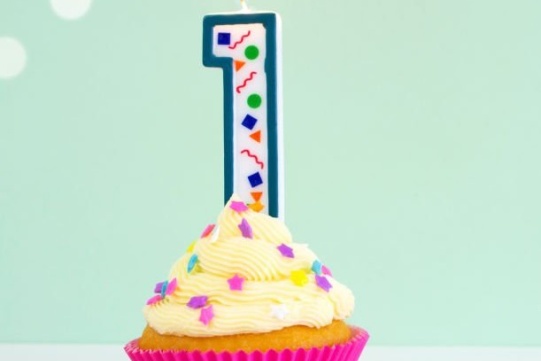 babeczka w różowej papilotce z wbitą świeczką w kształcie jedynki