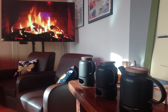 dzbanki z herbatą na tle kominka