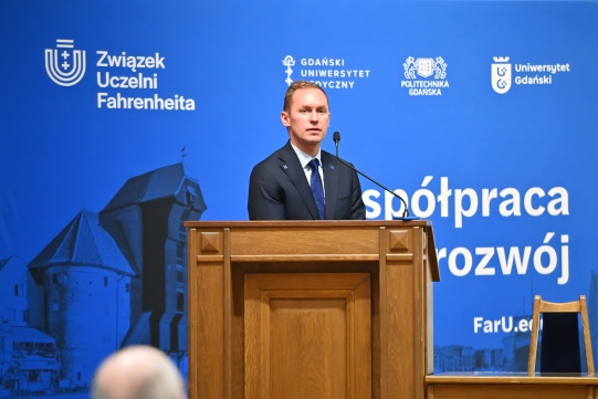 Dr inż. Marcin Jaskólski na tle banera.