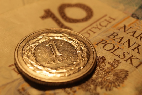 Banknot 10 zł a na nim leży moneta 1 zł