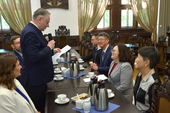 Vice Rector Sienkiewicz speaking to an Asian delegation sitting at the table