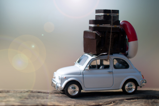 a car carrying suistcases on the roof