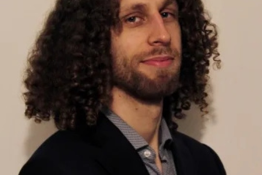 Na zdjęciu mężczyzna z lokowanymi włosami