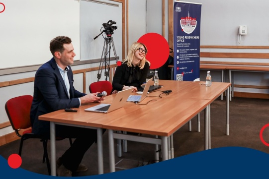 A photograph showing the presenters seated at a table.