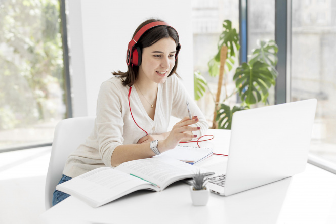 Woman in headphones sitting in front of her laptop studying