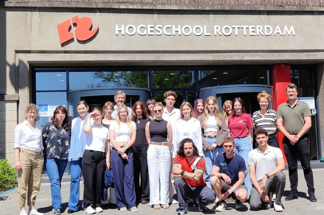 Grupa kilkunastu osób stoi przed wejściem do budynku uczelni Hogeschool Rotterdam